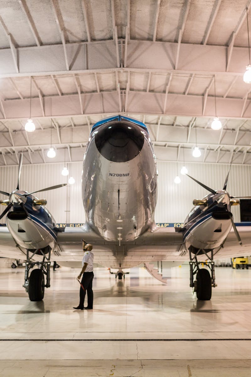 Front view of a vintage airplane in a well-lit hangar, showcasing aviation technology.